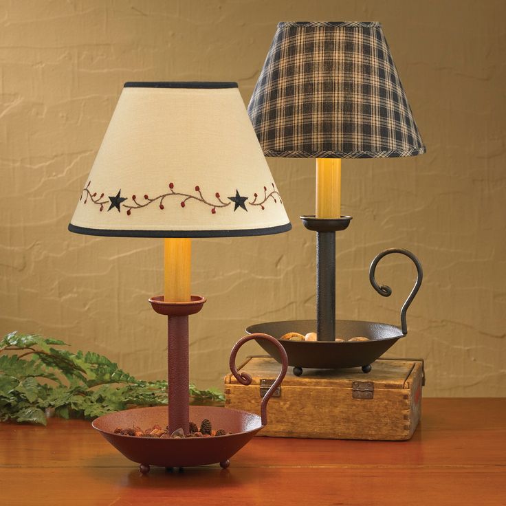 a lamp that is sitting on top of a table next to a bowl and pot