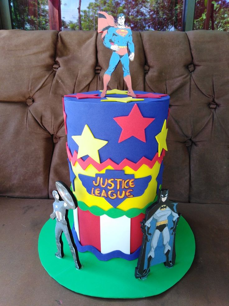 a birthday cake made to look like a giant cupcake with a superman figure on top