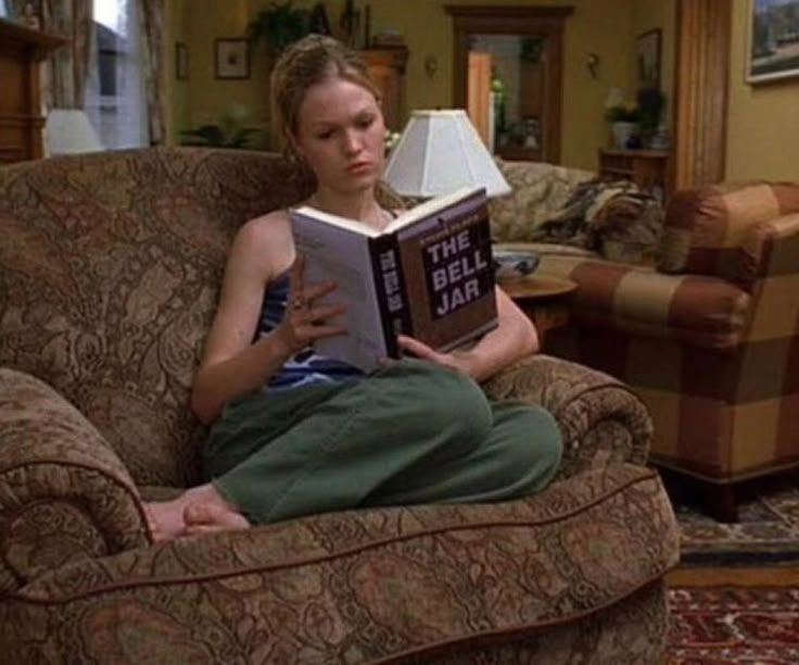 a woman sitting in a chair reading a book