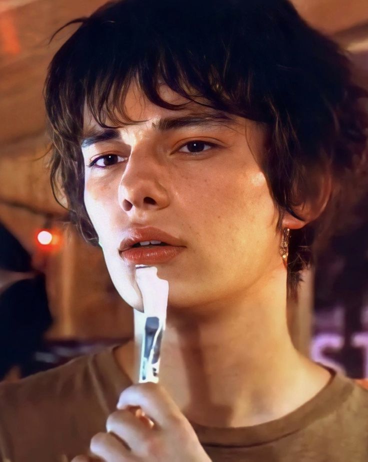 a young man brushing his teeth with an electric toothbrush