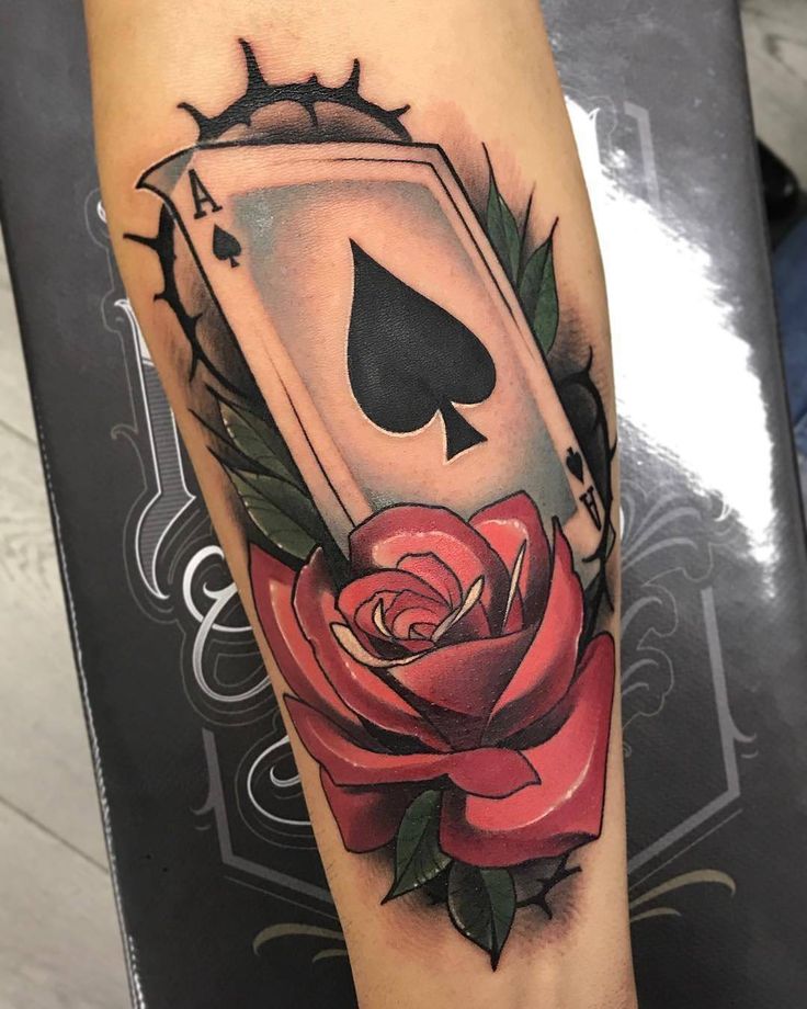 a rose and playing card tattoo on the arm