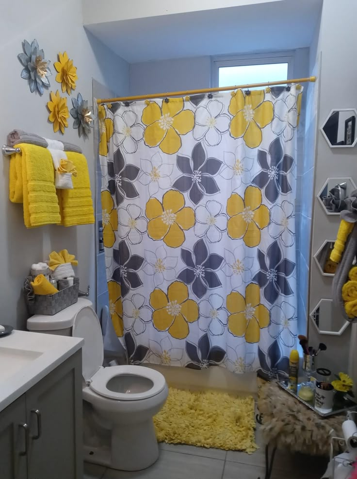 a bathroom with yellow and gray decor on the shower curtain