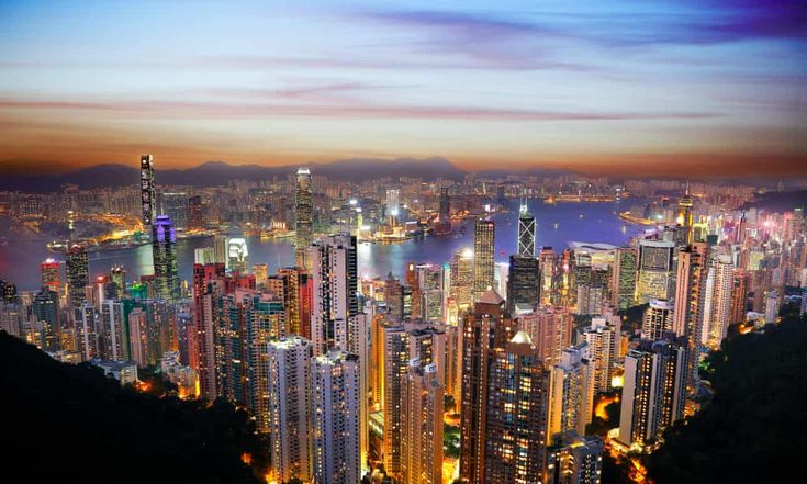 an aerial view of hong kong at night with the city lights glowing in the foreground