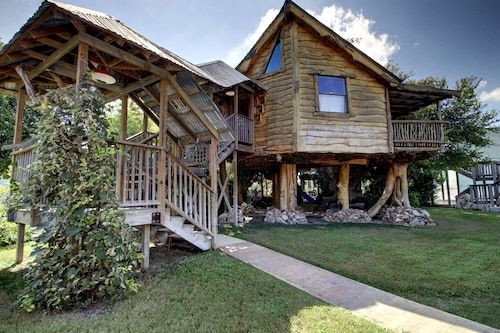 a wooden house sitting on top of a lush green field