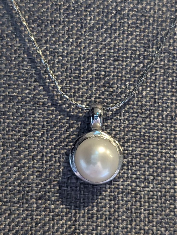 "Fine Pearl Pendant necklace featuring large 9mm white Pearl set in a 18k White Gold Plate pendant. Chain is solid 18k White Gold. This would make a lovely wedding necklace. HALLMARKS Chain is hallmarked 18k and test as such. Pendant is 18k GP. MEASUREMENTS 16\" long chain with 5/8\" x 3/8\" pendant. CONDITION In very good to excellent condition, please use all pictures as part of item's description. MATERIALS 18k White Gold (Chain) 18k White Gold Plate, Genuine 9mm Pearl. CLOSURE Spring ring cl Classic White Gold Pearl Necklace As Gift, White Pearl Necklace For Wedding, Classic White Gold Pearl Necklace For Anniversary, Classic White Gold Jewelry With Pearl Pendant, Elegant Sterling Silver White Necklace, Classic Pearl Pendant Necklace For Wedding, Elegant Formal Solitaire Necklace With Polished Finish, Pearl White Fine Jewelry Necklace For Formal Occasions, Classic Round Cut Bridal Necklace For Anniversary