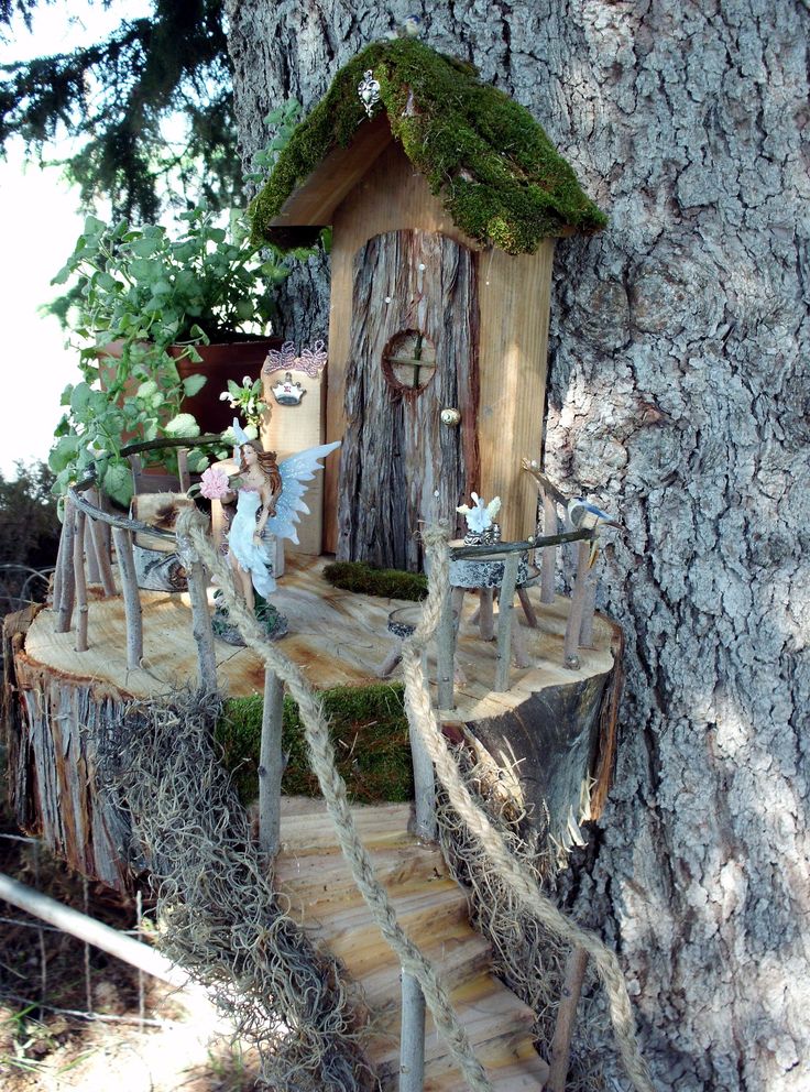 a tree house built into the side of a tree trunk with stairs leading up to it