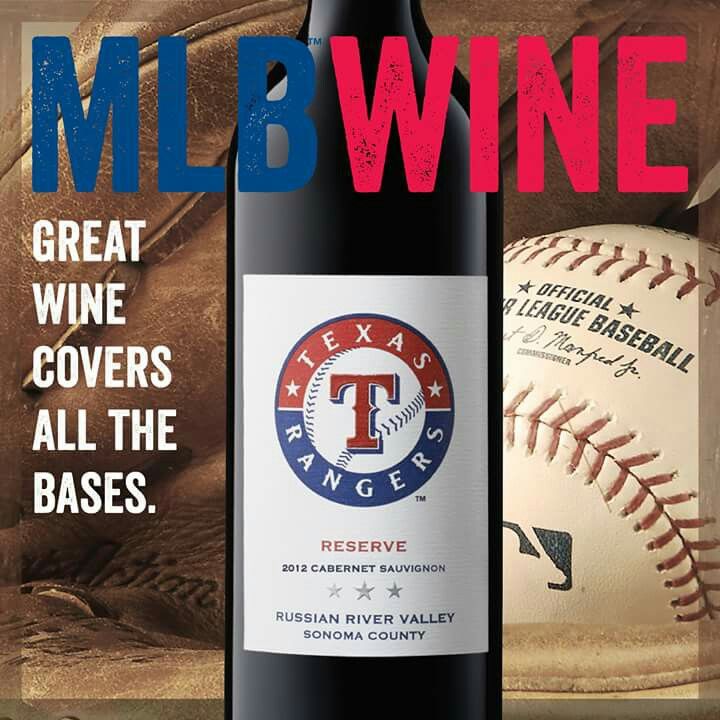 a bottle of wine sitting next to a baseball