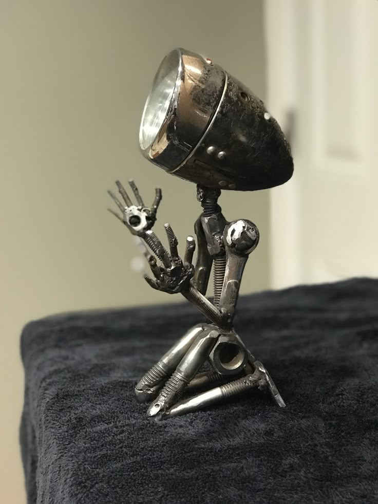 a small metal figure holding a lamp on top of a bed