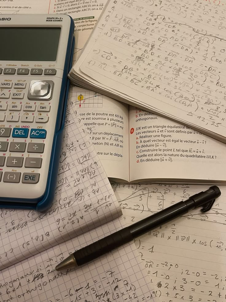 a calculator, pen and notebooks on top of some paper with numbers