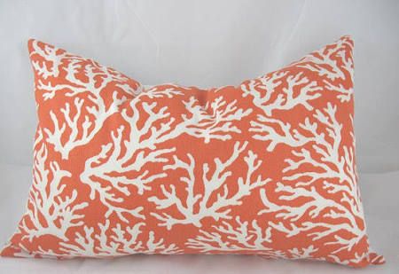 an orange and white coral pillow on a white background