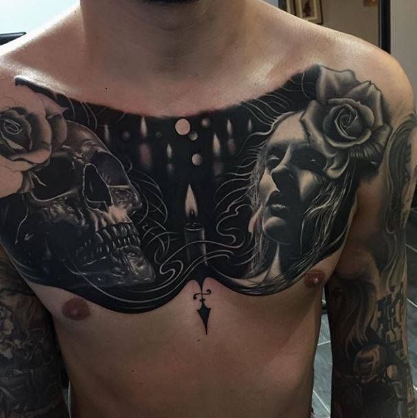 a man's chest with tattoos and roses on it