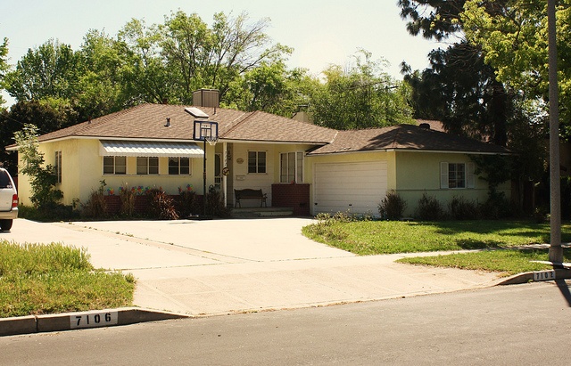 a house with a car parked in front of it on the side of the road