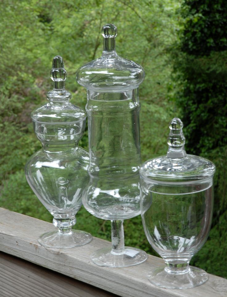 three glass vases sitting on top of a wooden ledge