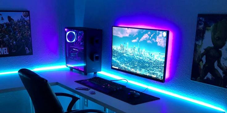 a computer desk topped with a monitor and keyboard next to a wall mounted speaker system