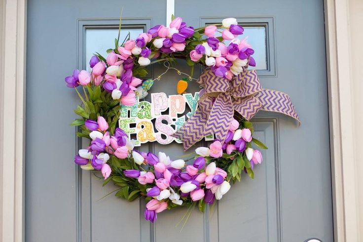 a purple and white wreath on a door with the words happy birthday written on it