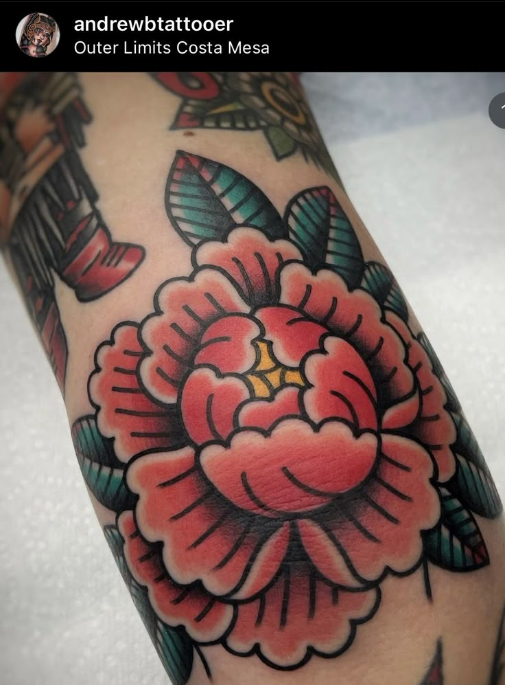 a close up of a person's arm with a flower tattooed on the side