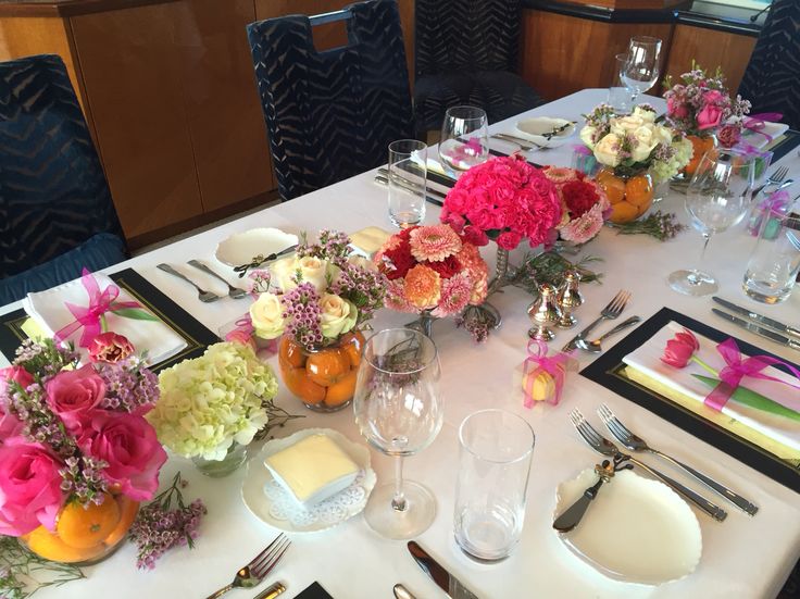 the table is set with flowers and place settings