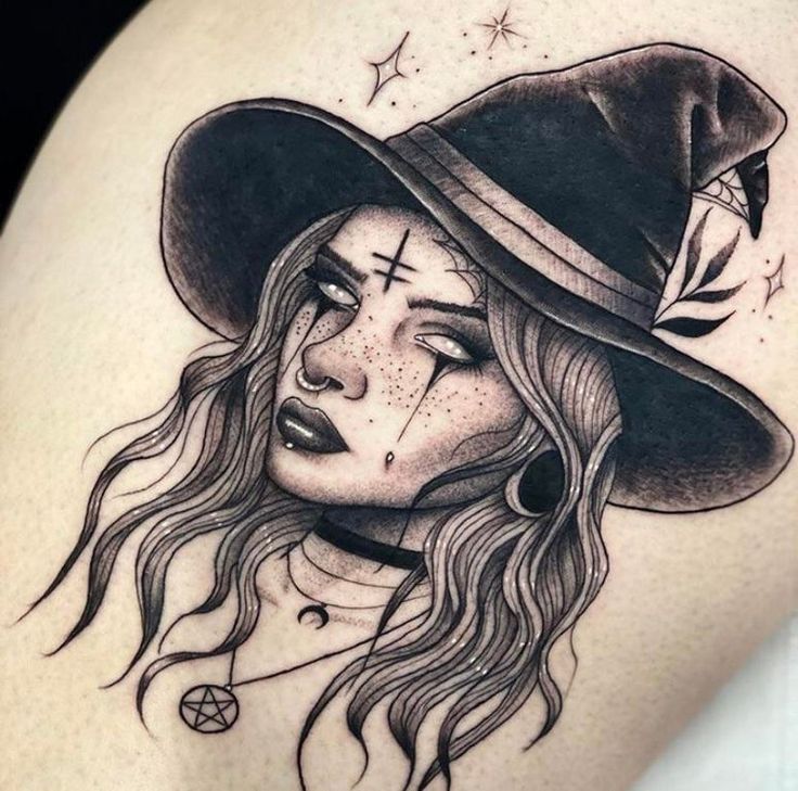 a woman with long hair wearing a black hat and cross tattoo on her thigh,