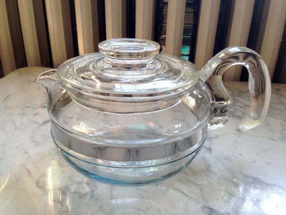 a clear glass tea pot sitting on top of a counter