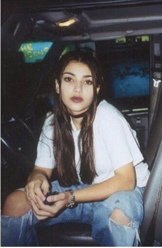 a woman sitting in the back seat of a car with her hand on her hip