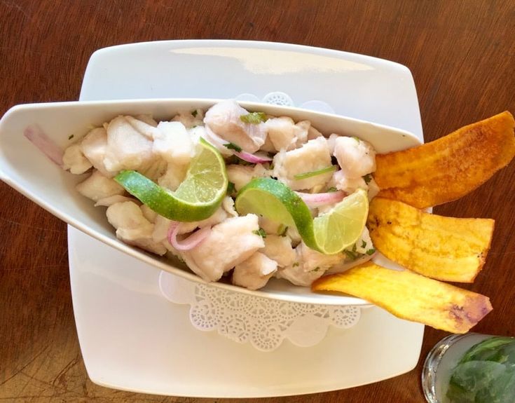 a white bowl filled with food on top of a wooden table