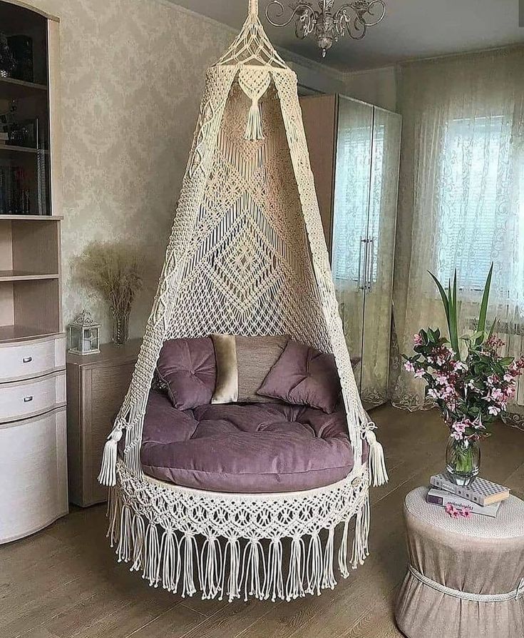 a white hammock hanging from the ceiling in a living room