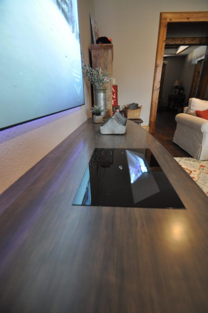 a living room with wood flooring and a large projector screen