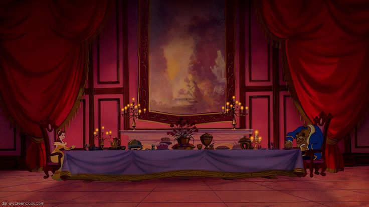 the table is set up in front of an ornate painting and red drapes with candles on it