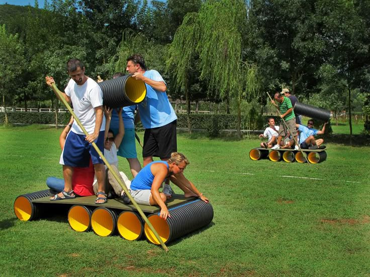 several people are playing with giant objects in the park