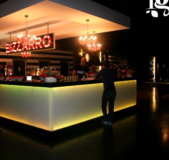 a man standing in front of a bar at night