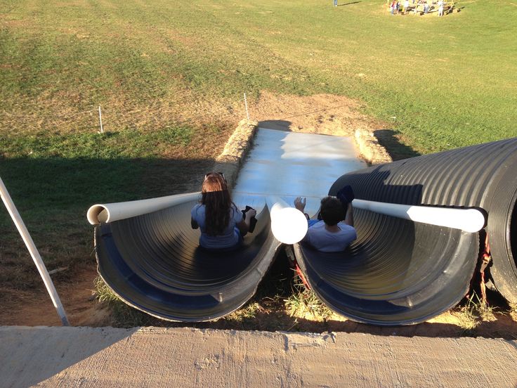 there are two pipes connected to each other on the side of a building with grass in the background