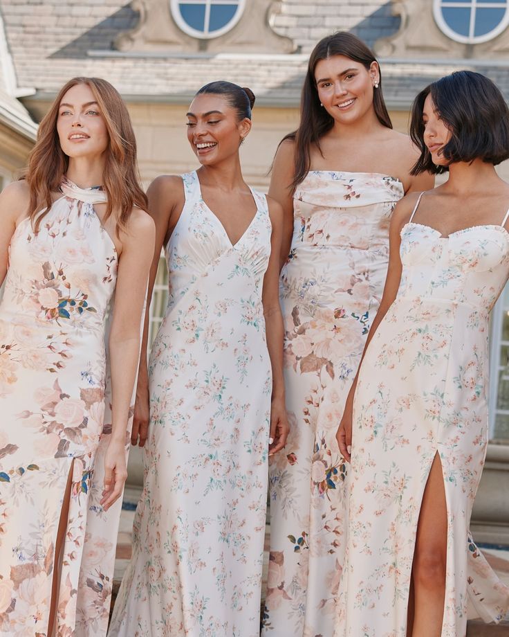 three women in dresses standing next to each other and one is smiling at the camera