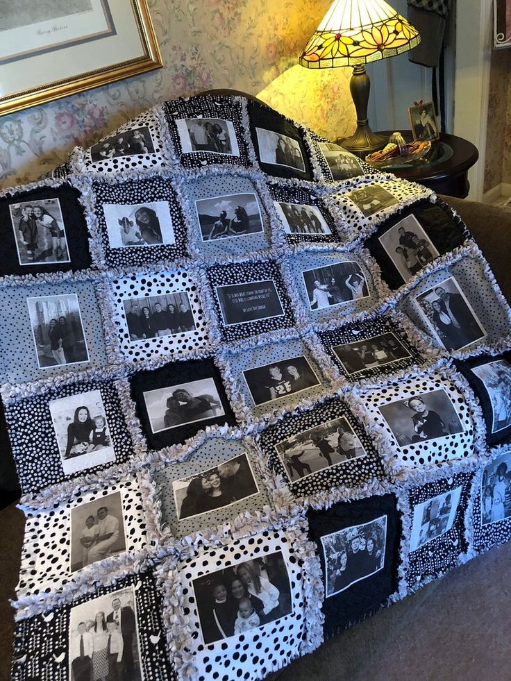 a black and white photo quilt on top of a couch next to a table lamp