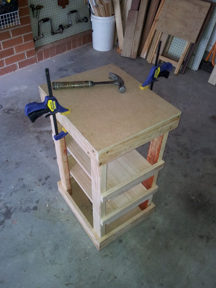 a workbench with tools on top of it in a room filled with wood