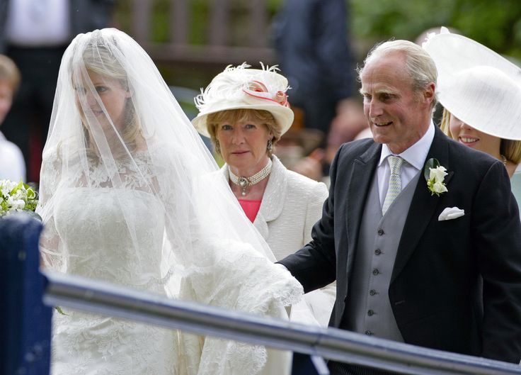 an older couple walking down the aisle with their wedding dress and veil draped over them