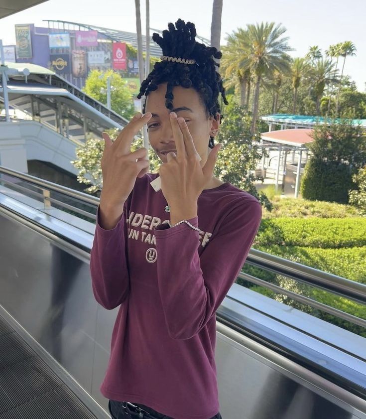 a woman standing on an escalator holding her hand up to her face