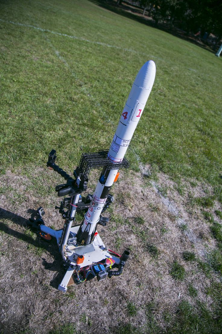 a rocket sitting on top of a grass covered field