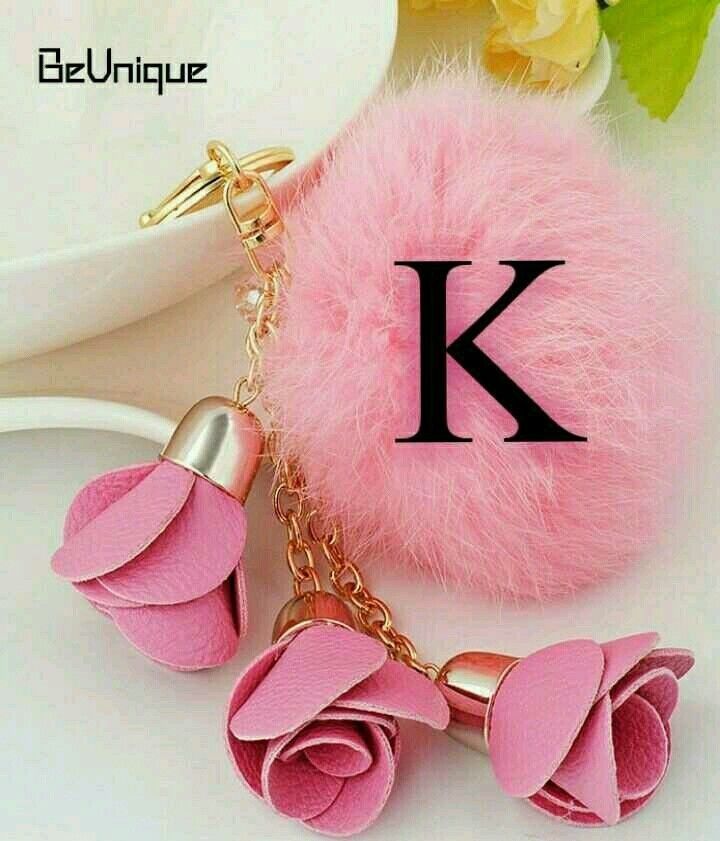 a pink keychain with flowers on it and a letter k in the background