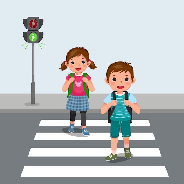 two children crossing the street in front of a traffic light, one with a backpack