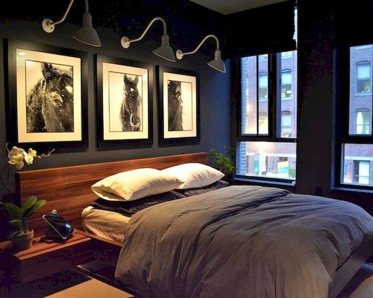 a bed sitting under three framed pictures on the wall next to a window in a bedroom