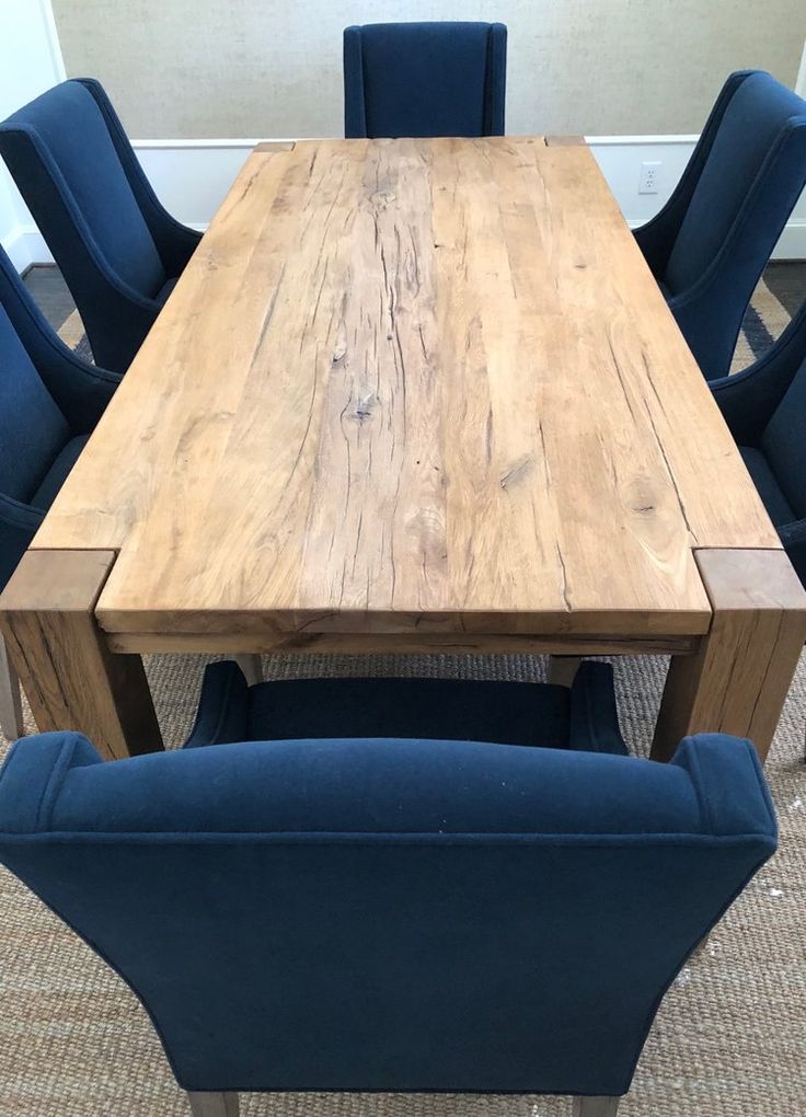 a wooden table with blue chairs around it