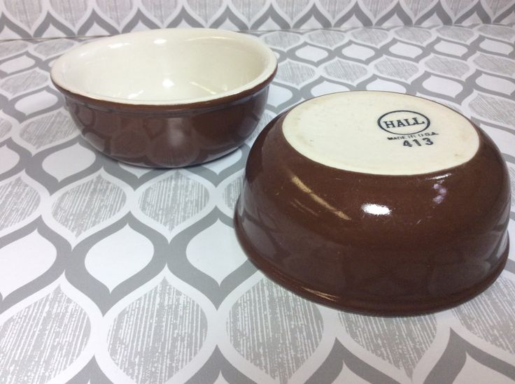 two brown and white bowls sitting on top of a tablecloth covered table with patterns