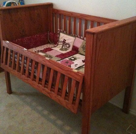 a wooden crib in the corner of a room