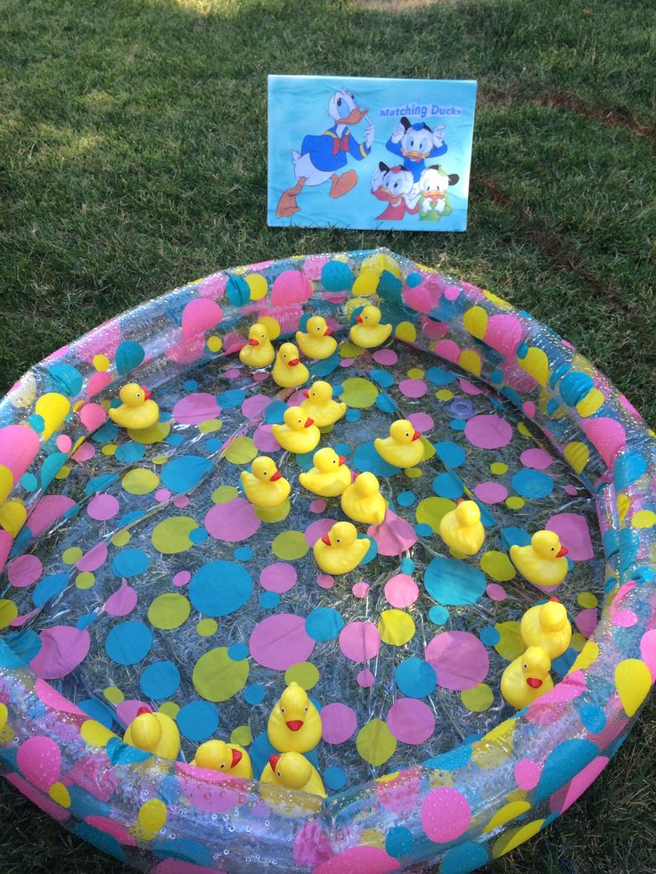 an inflatable kiddie pool with rubber ducks on it and a card next to it