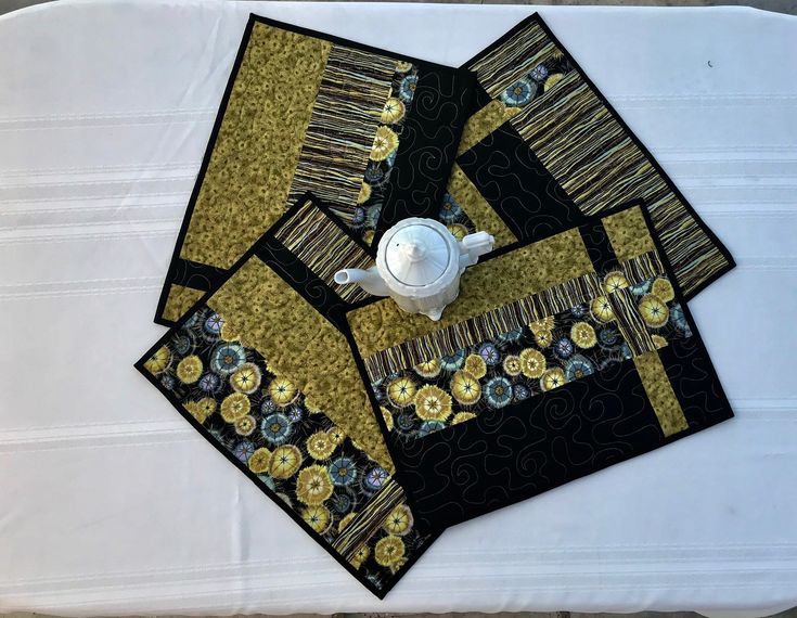 the table is covered with black and gold placemats, napkins, and cups