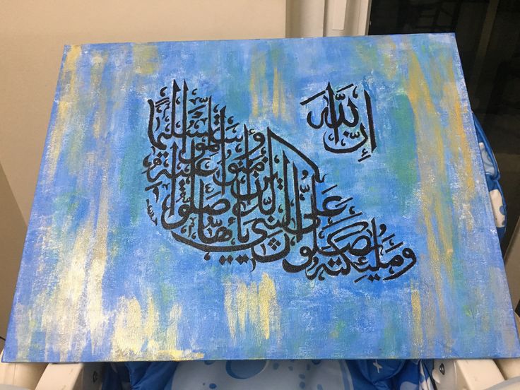 a painting with arabic writing on it in blue and yellow colors, sitting on top of a chair