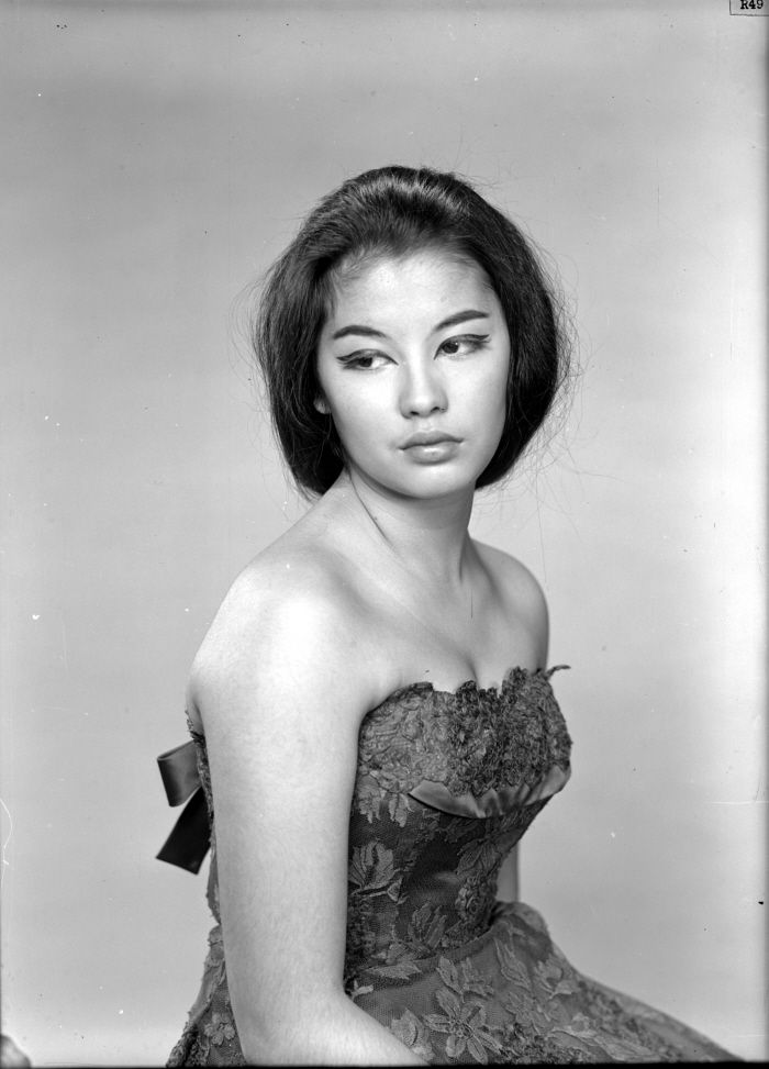 an old black and white photo of a woman in a dress