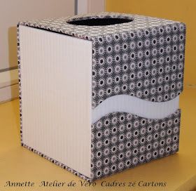 an empty box sitting on top of a yellow table next to a white and black wall