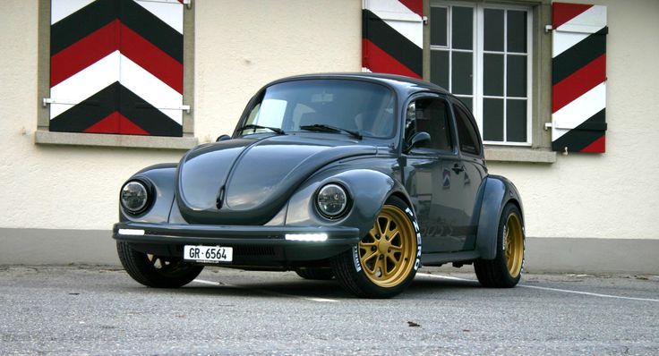 a gray and yellow beetle parked in front of a building