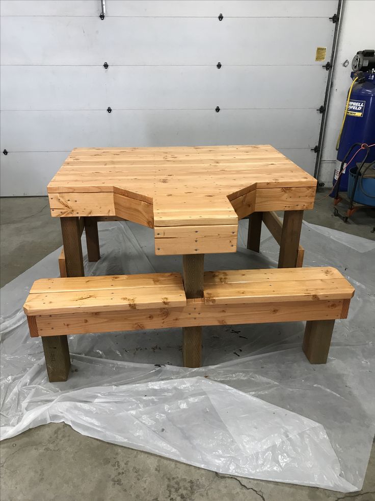 a wooden table and two benches in a garage